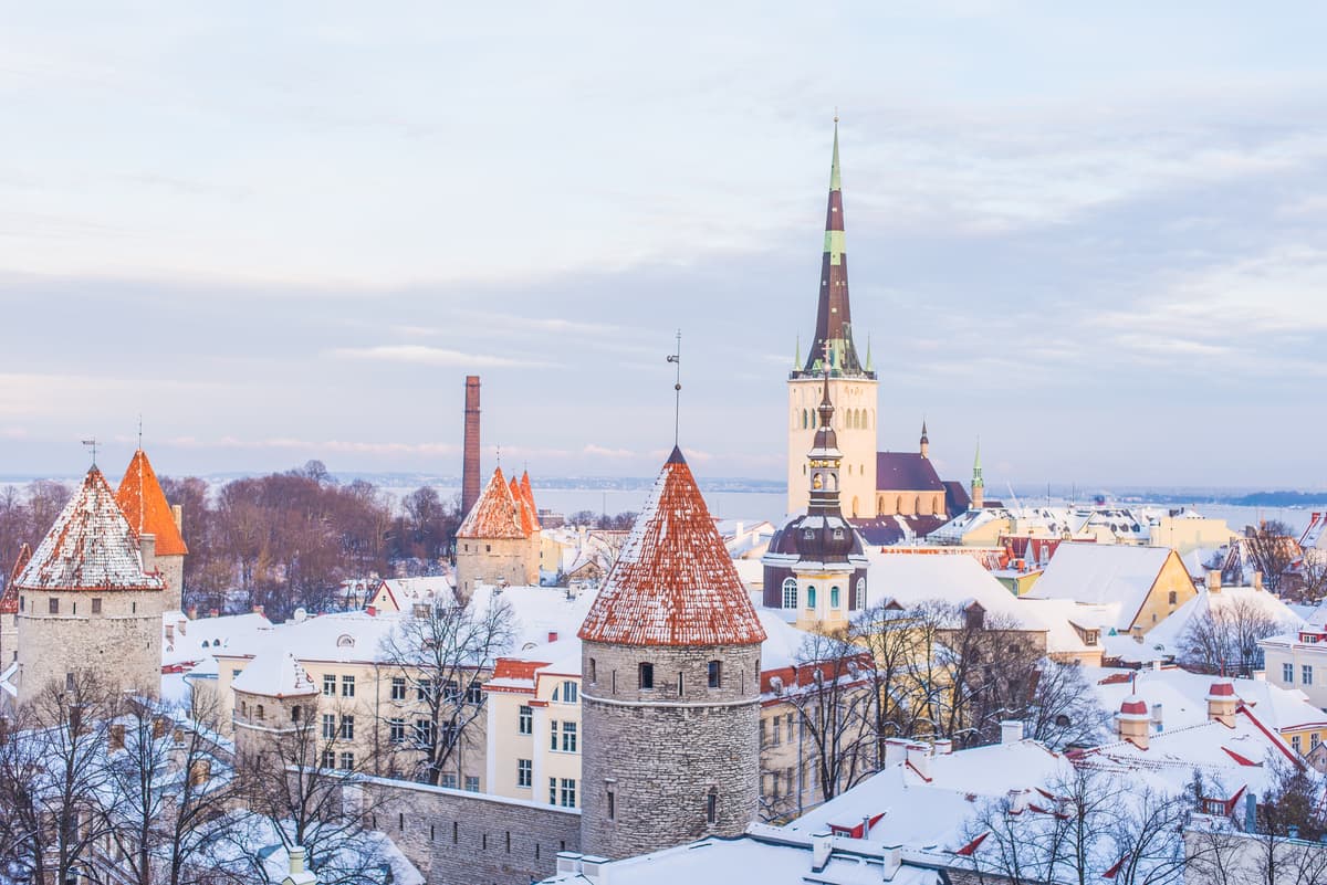 Tallinn Old Town under snow: church spires and red-roofed towers above the rooftops